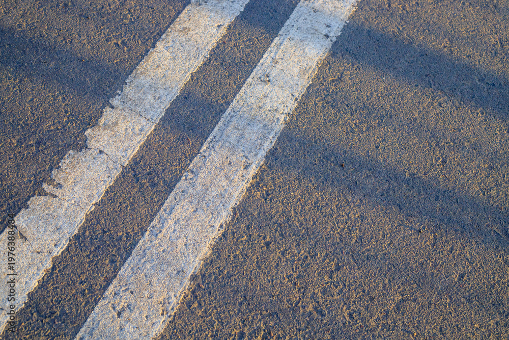 Fototapeta premium Double white dividing strip on the asphalt of the road.
