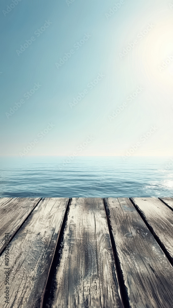 Fototapeta premium Weathered wooden planks lead to tranquil ocean waters under clear blue sky, creating a sense of serenity and inviting escape in a peaceful coastal setting.