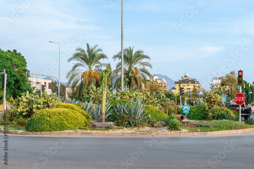 Green roundabout at Ataturk Blvd and D400 in Alanya with cacti and palms. Vibrant urban landscape featuring Turkish road infrastructure and a 