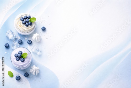 Desserts with blueberries arranged on light gradient background with copy space