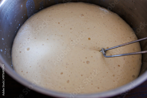Close up of rising yeast dough with bubbles, fermentation process in homemade baking