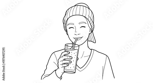 A cheerful person wearing a knitted beanie happily drinks from a glass with a straw, enjoying a refreshing beverage.
