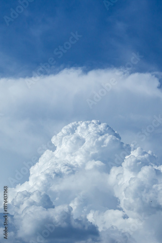 Vertical dramatic cumulonimbus cloud formation in blue sky with copy space