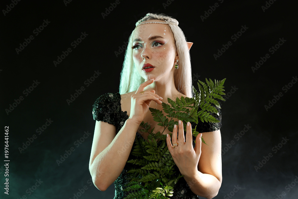 Obraz premium Beautiful elf girl with floral decor on black background with smoke