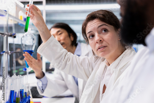 Foto Close up of molecular biologists in lab inspecting chemical solution clarity in vials for purity verification