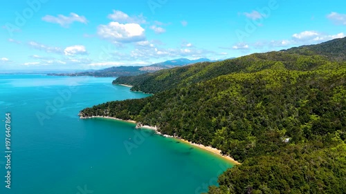 Aerial view of the Abel Tasman coastline where turquoise waters meet lush green forests and sandy beaches, Abel Tasman National Park, Tasman Region, New Zealand.