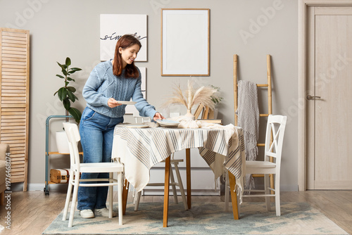 Young woman putting plates ...