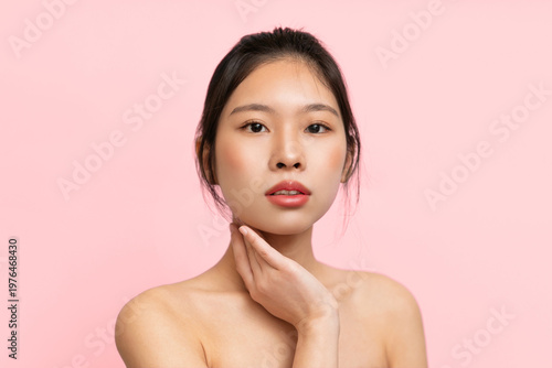 Tableau sur toile A young model stands in front of a pink backdrop