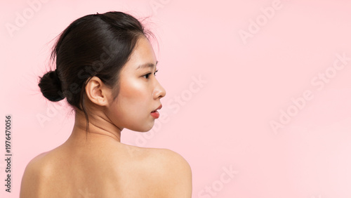 Tableau sur toile A person stands with a profile view against a light pink background
