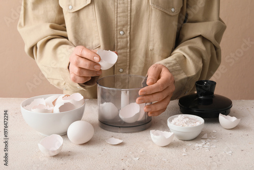 Woman grinding egg shells w...