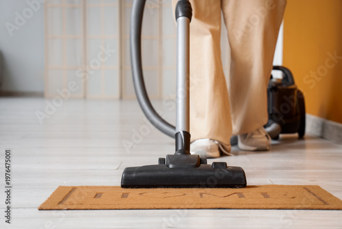 Legs of woman vacuum cleani...
