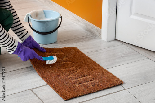 Janitor cleaning doormat wi...