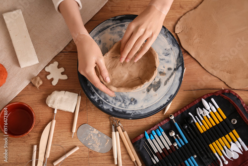 Young woman forming clay pl...