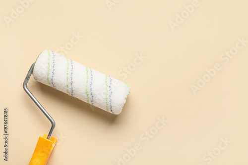 Paint roller on beige backg...