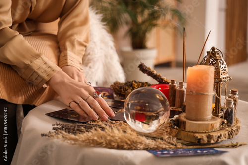 Foto Female fortune teller reading tarot cards on table in room