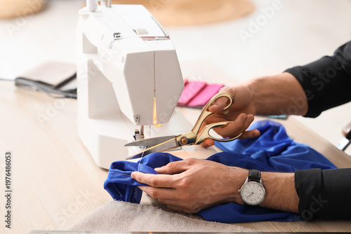 Young male tailor with sewi...
