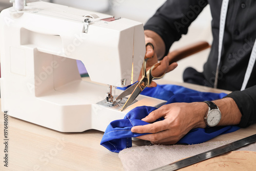 Young male tailor with sewi...