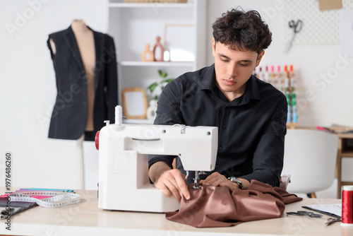 Young male tailor using sew...