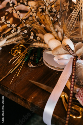 Florist workspace with tools and dried flowers on a wooden table, capturing the process of creating handmade bouquets. A warm and authentic scene