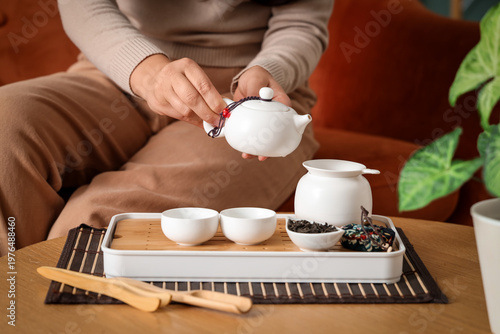Young woman pouring tea fro...