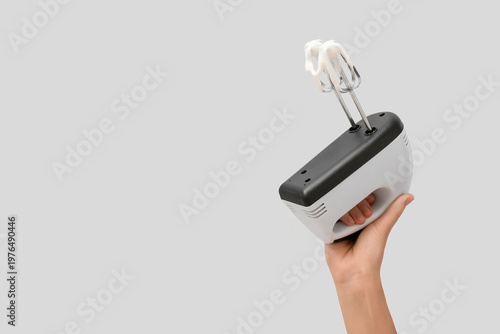 Woman holding electric mixe...