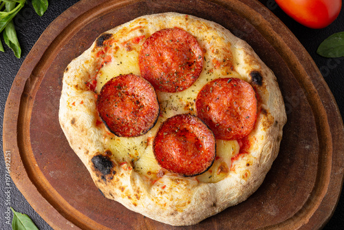 Billede på lærred pizza brotinho de pepperoni com queijo sobre tabua de madeira com folhas verdes