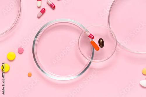Petri dishes and different pills on pink background, closeup