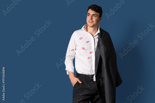 Photos Young man with kiss marks on his shirt against dark blue background