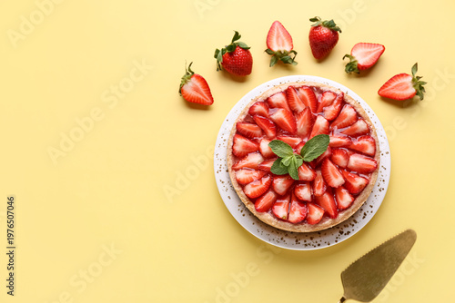 Plate of sweet strawberry tart with mint and fresh berries on yellow background