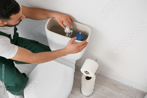 Male plumber replacing fill...