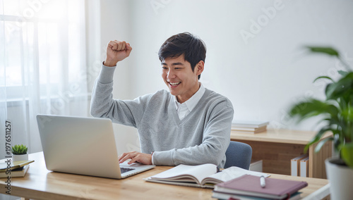 合格の知らせに喜ぶ日本人男子学生の学習机でのひととき