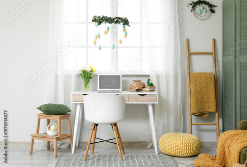 Interior of office decorated for Easter with workplace and ladder