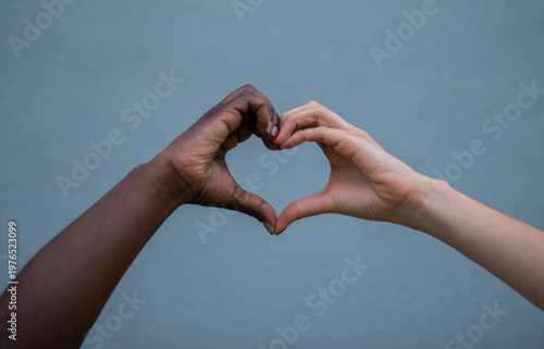 Quadro su tela Manos de diferentes tonos de piel formando un corazón sobre fondo neutro, símbol