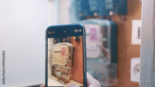 Mobile Phone in Hand Taking a Photo of Electricity Counter for Audit | Monthly Home Energy Check and Bill Management | Person Recording Utility Data for Online Reporting