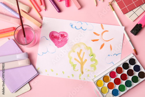 Children's drawing with markers, watercolor paints and brushes on pink backgr...