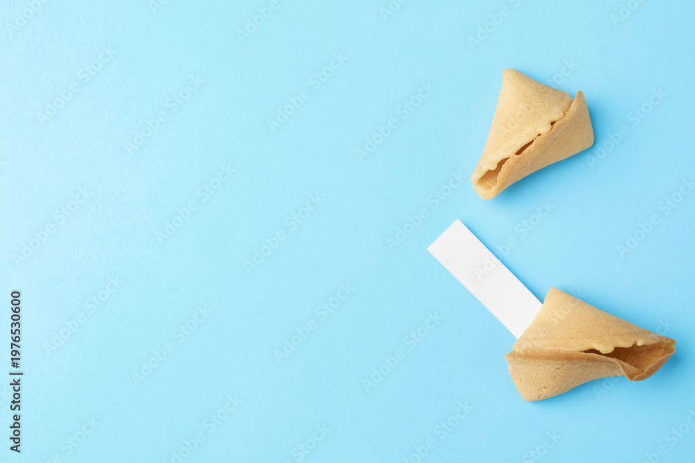 Naklejka premium Tasty fortune cookie with prediction on light blue background, top view. Space for text
