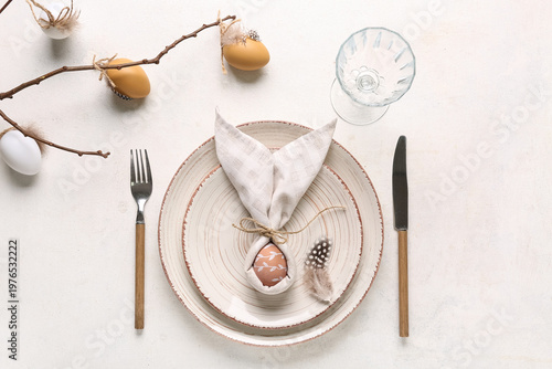 Beautiful table setting with Easter eggs and tree branch on white background