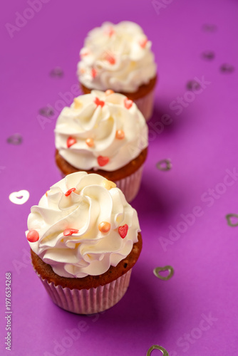 Tasty cupcakes for Valentine's Day on purple background