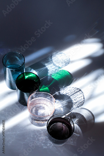 Colorful glass of water under sunlight reflection on white background. Minimal modern background.
