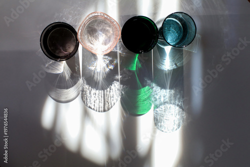 Colorful glass of water under sunlight reflection on white background. Minimal modern background.
