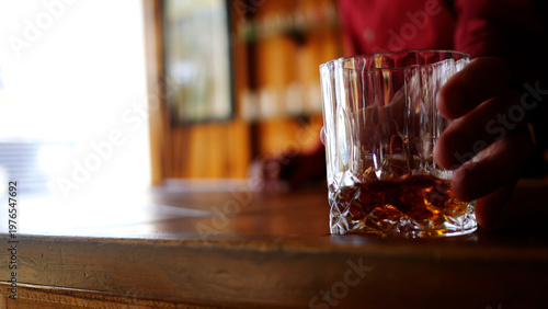 Defocused Bartender Places Whiskey Glass in Trendy Tavern or Bar