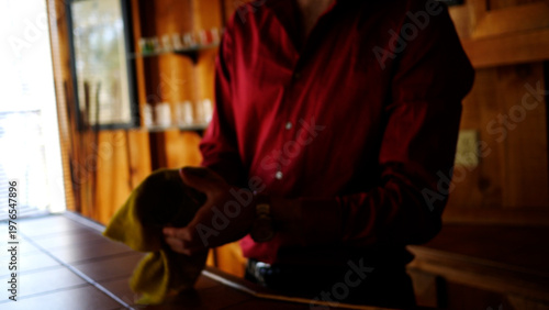 Defocused Bartender Cleans a Whiskey Glass in Trendy Tavern or Bar