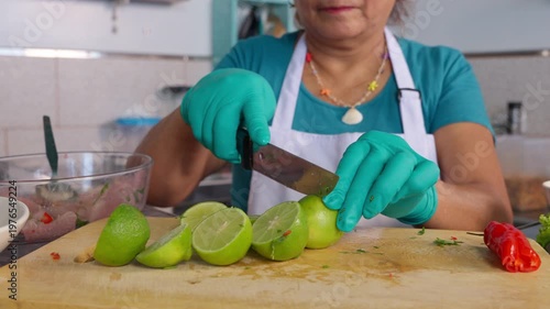 Peruvian senior chef cutting limes for ceviche preparation