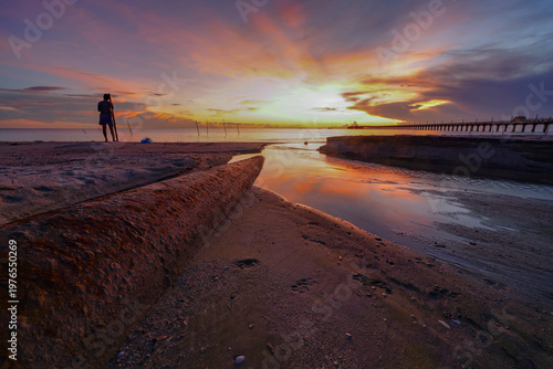 Dramatic sunrise colors reflecting in the shallow water.