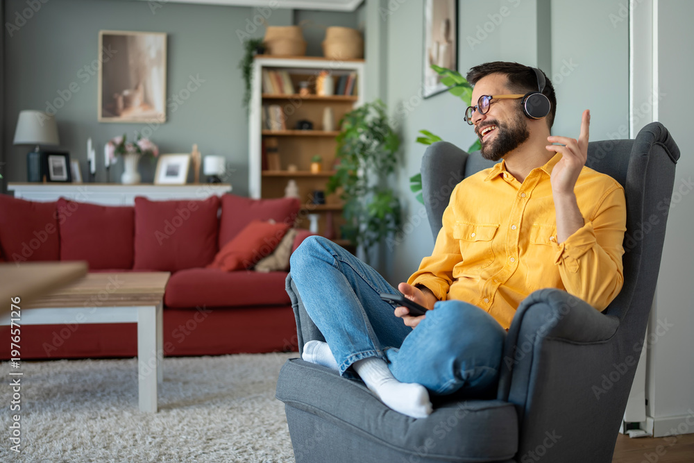 Obraz premium Man enjoying music listening with wireless headphones at home