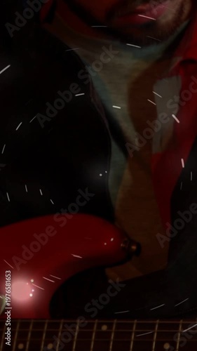 Vertical video: Guitarist tuning red guitar for music, shot rising showing strings, lights orbiting