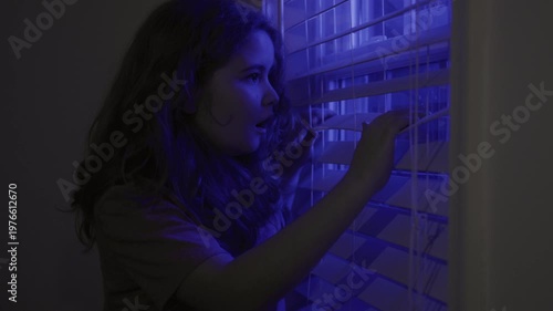 Child in alert police scene light. Kid emotional fear and anxiety. Child fear night police lights. Child anxiety near window with police light. Kid scared indoors at night crime scene.