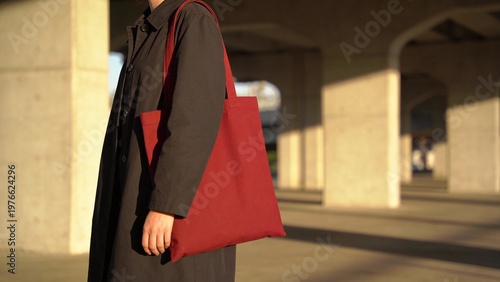 Minimalist Side View Close Up Of Person Carrying Red Tote Bag In Warm Sunlight Urban Fashion Scene