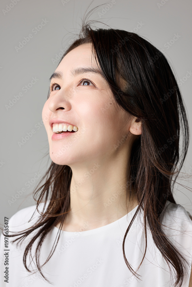 Fototapeta premium 上を見上げて笑う40代女性のポートレート