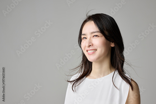 横を向いて微笑む40代女性の横構図ポートレート